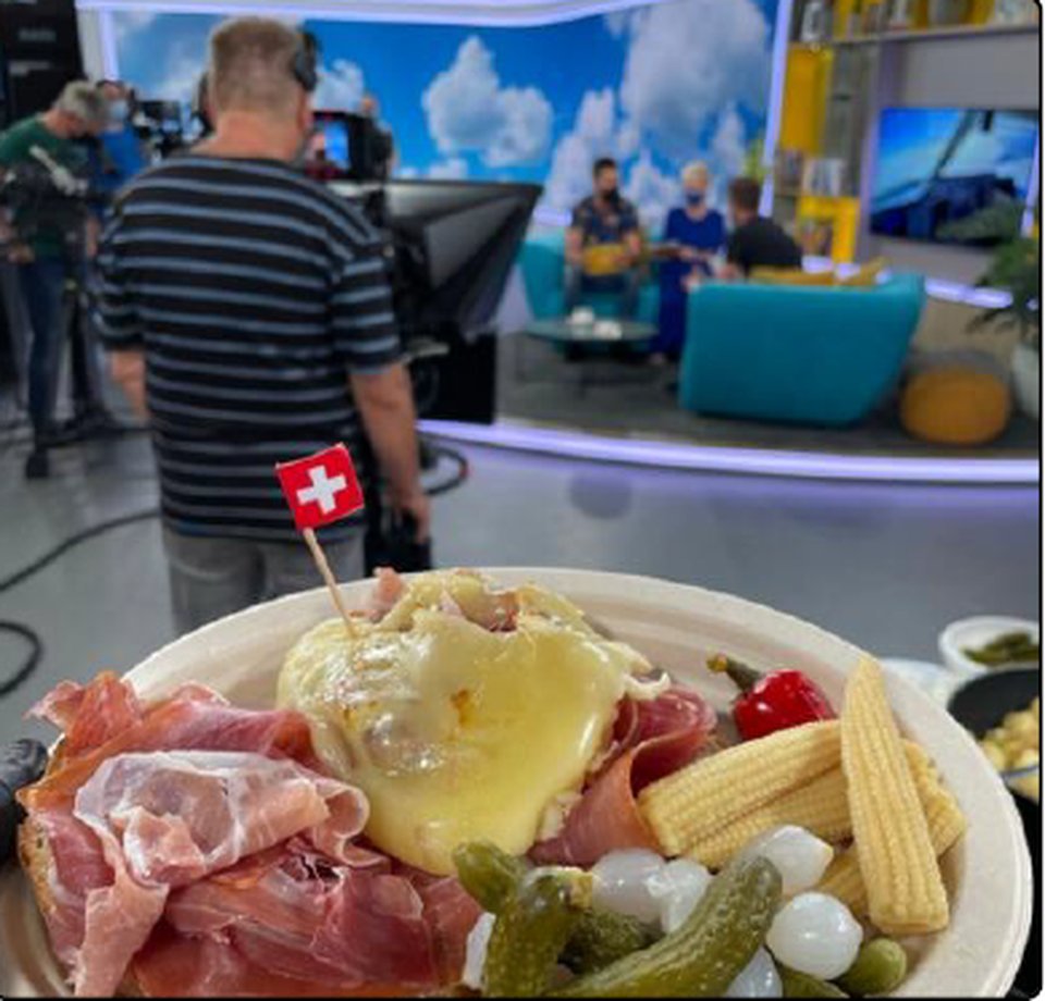 A plate of raclette with a Swiss flag in a TV studio